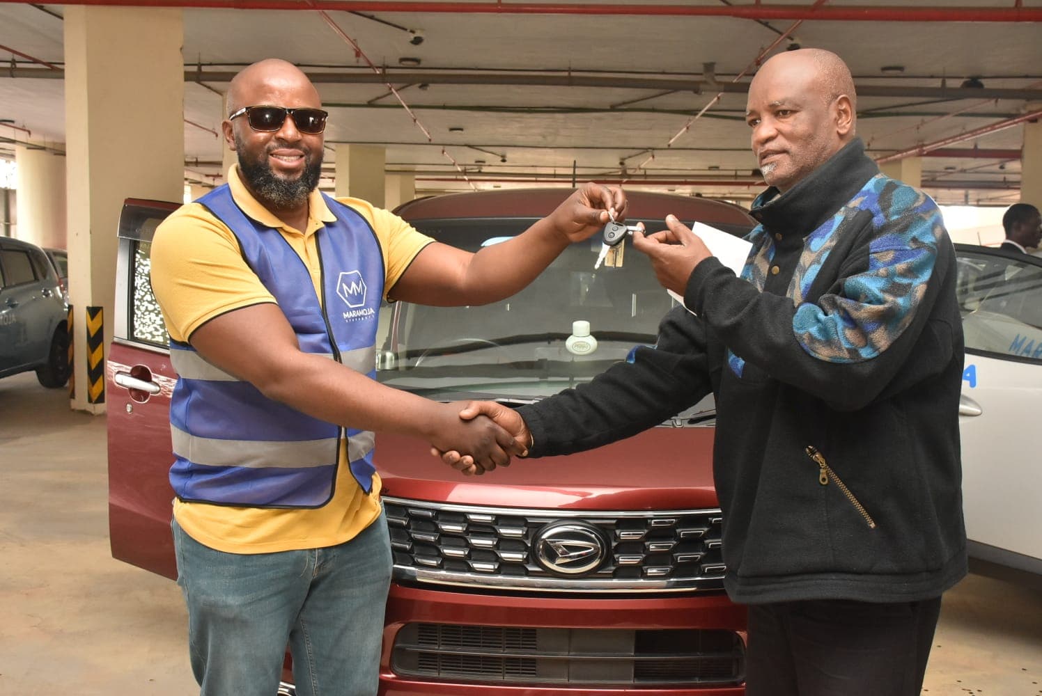 Black vehicle concierge handing over car keys